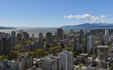 View of downtown Vancouver from the top of the Blue Horizon Hotel in Vancouver. You can see the mountains in the background as well as the ocean.