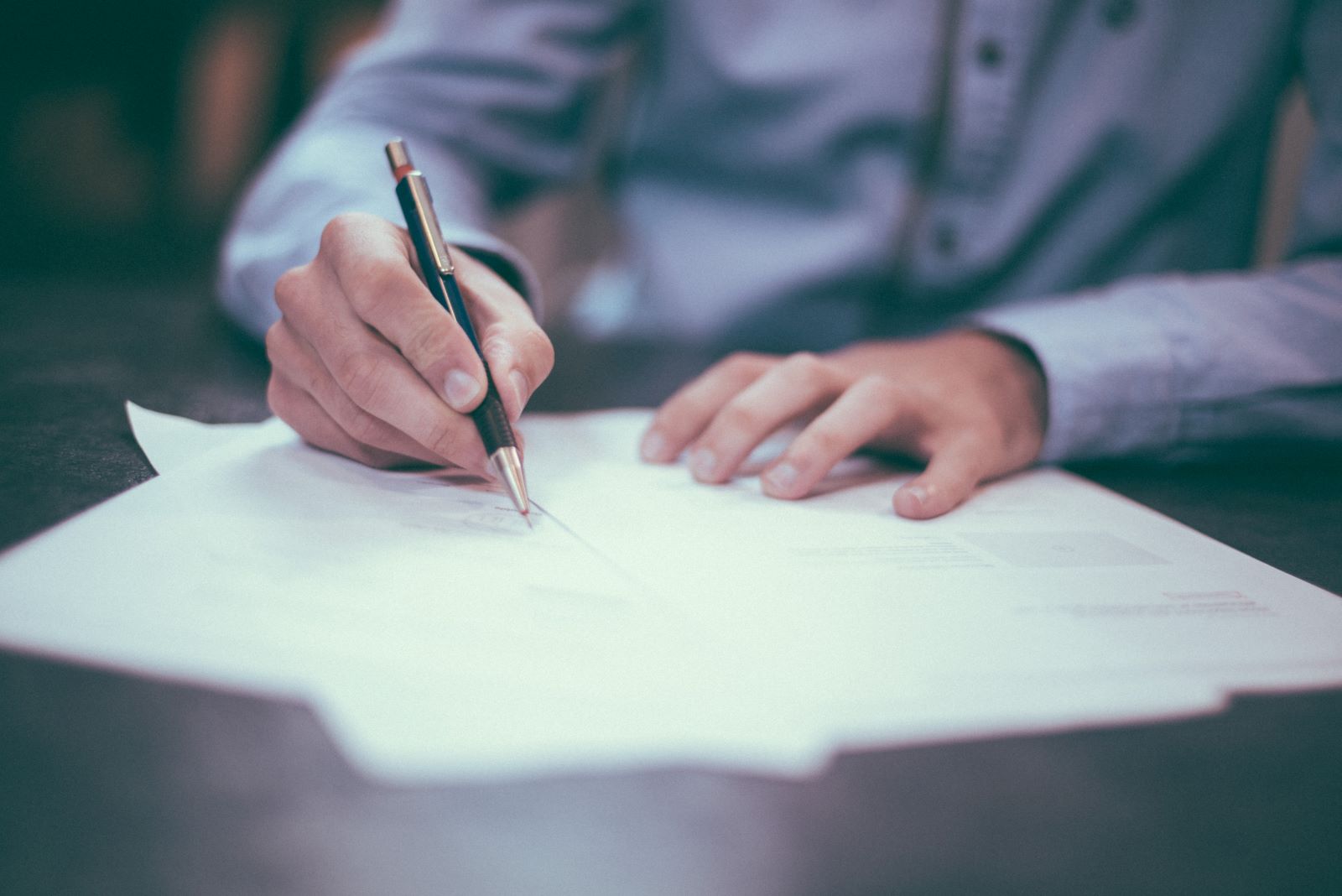 Close-up image of someone filling out forms