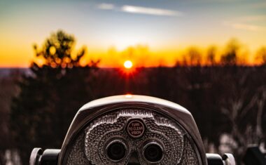 Photo of a stand binocular pointed at a sunset