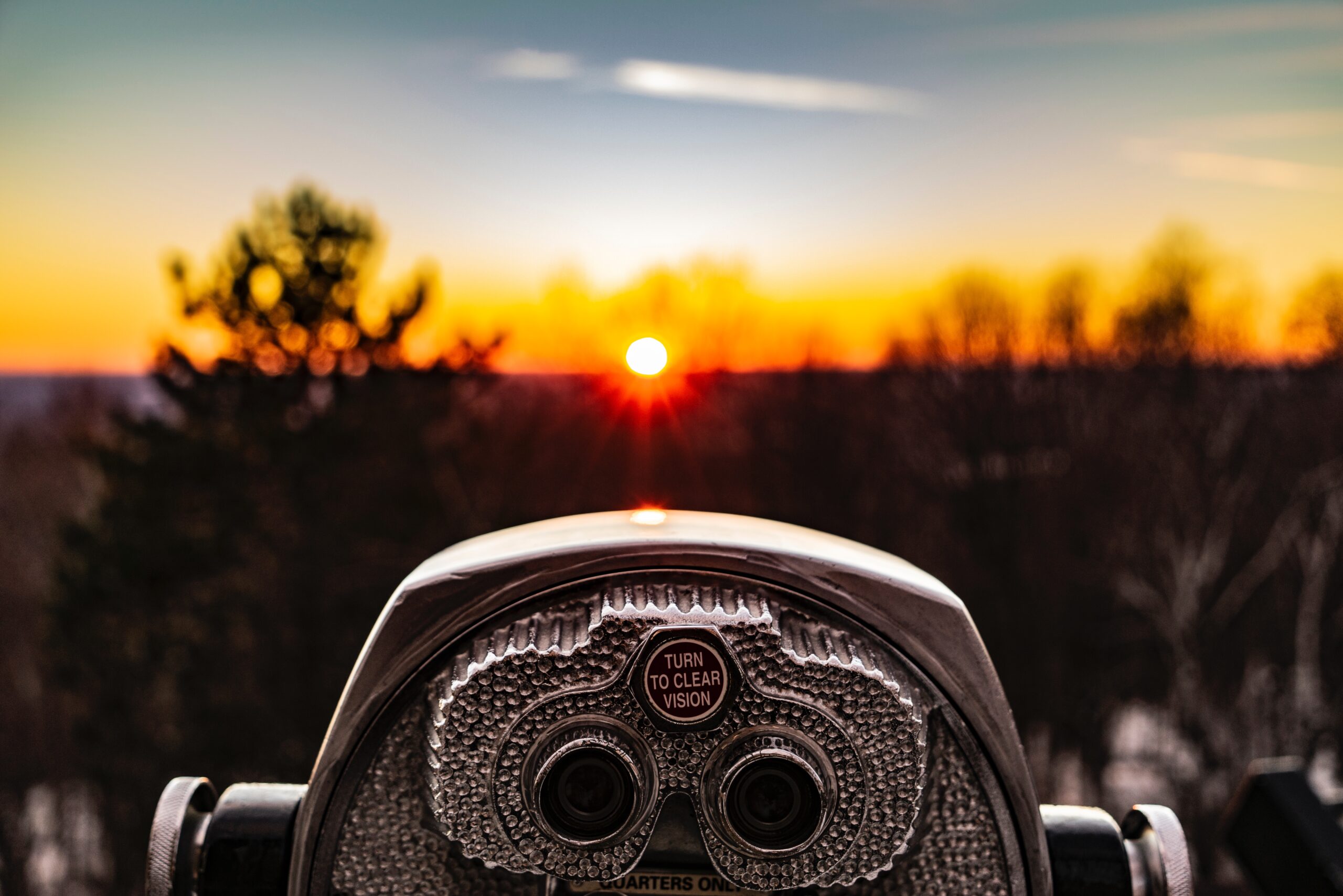Photo of a stand binocular pointed at a sunset