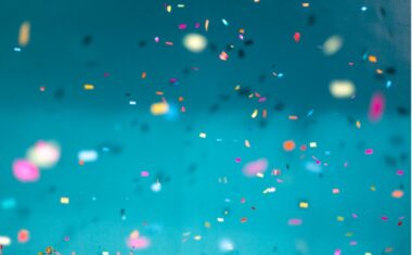 Confetti paper falling in front of a blue backdrop