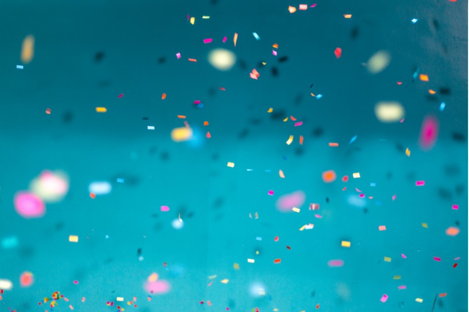 Confetti paper falling in front of a blue backdrop