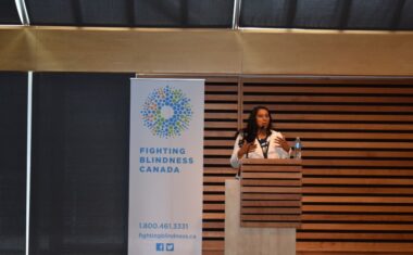 Dr. Deepa Yoganathan standing on stage speaking