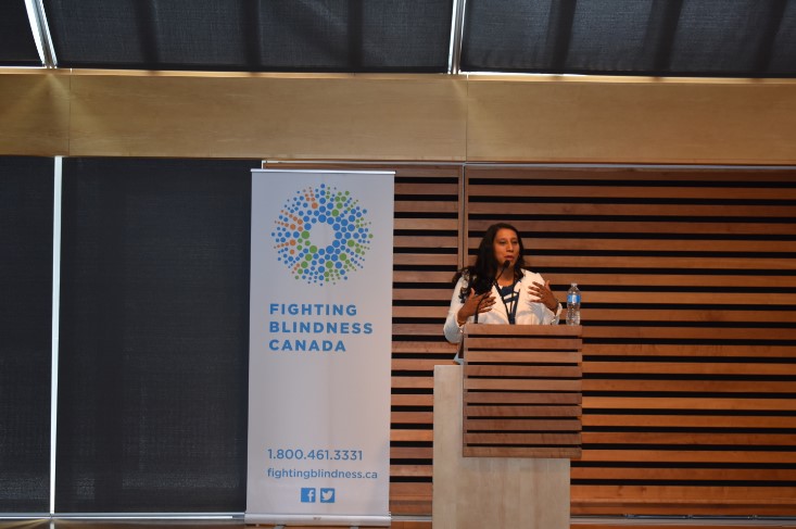 Dr. Deepa Yoganathan standing on stage speaking