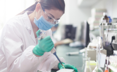 Female Scientist working in a lab with a mask and goggles on