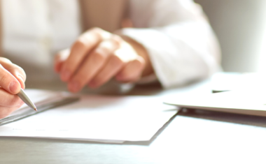 person sitting at desk signing documents