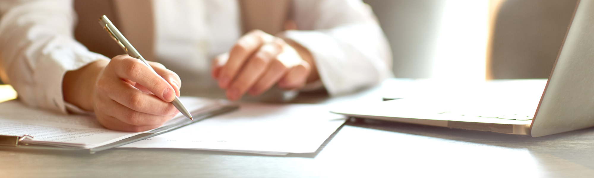 person sitting at desk signing documents