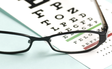 a pair of glasses resting on a paper with blurred letters