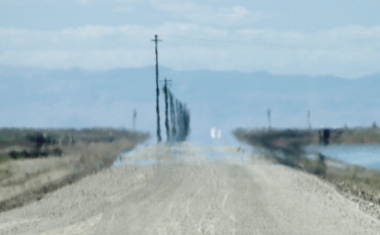 image of a long blurry road blending into a blue sky horizon