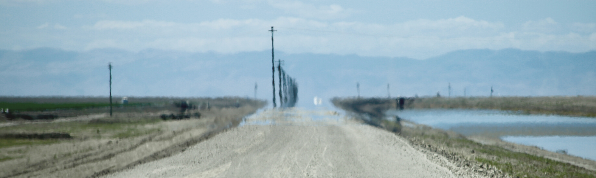 image of a long blurry road blending into a blue sky horizon
