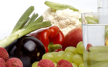 image of a variety of fruits and vegetables on a table with a jug and glass of water