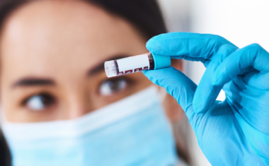 close up of scientist holding up treatment bottle