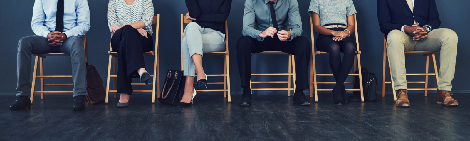 The image is of a group of candidates seated as they await an interview.