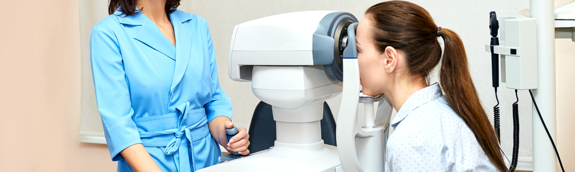 Image is of an optometrist standing before a medical device as a patient looks through the device and has her eyes checked.