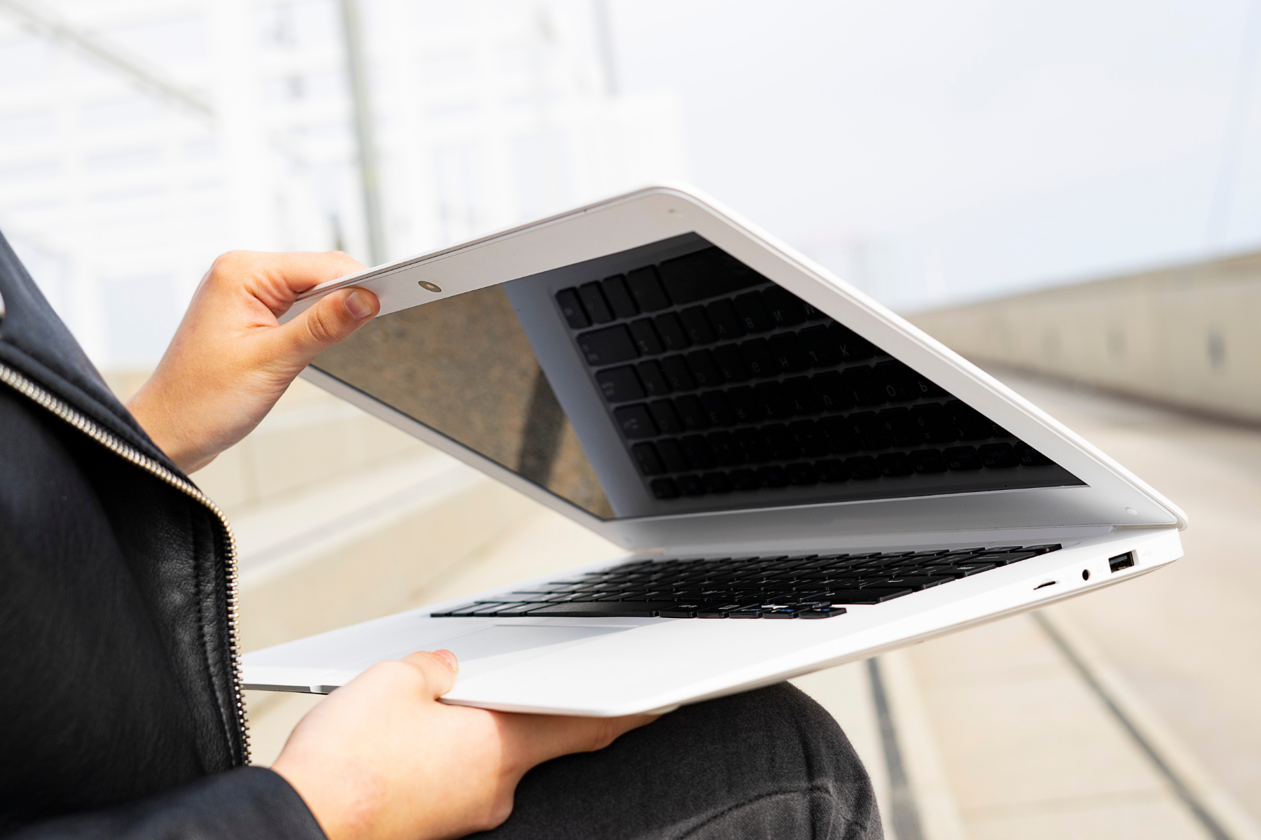Image is of a person closing their laptop