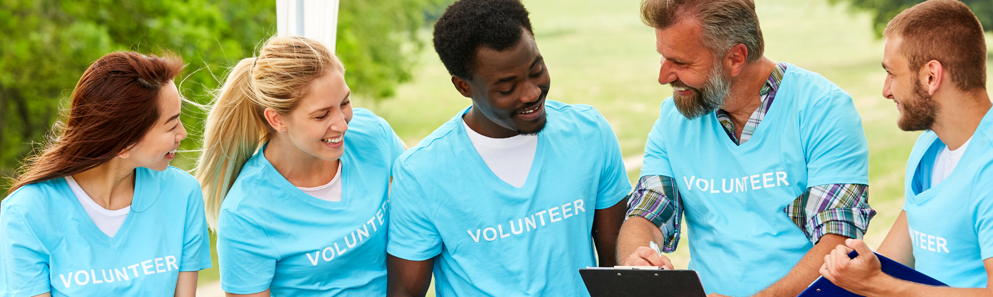 Image is of a group of volunteers smiling as they fundraise