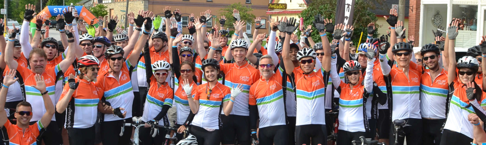 Image is of a group of cheering participants at a cycle for sight event