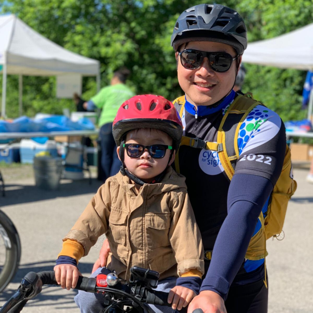 Image is of Dr. Stephan Ong Tone with his toddler son seated on a bicycle together 