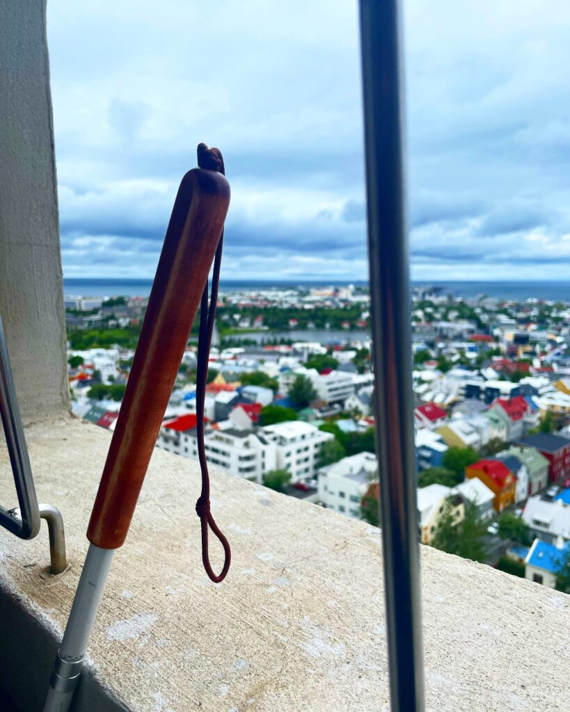Image is of a white cane overlooking city of Reykjavik