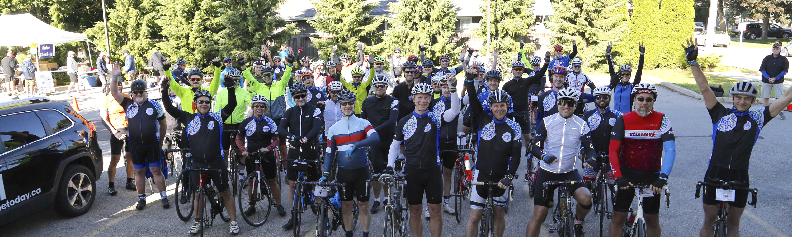 Image is of a large crowd of Cycle for Sight event goers smiling and cheering!