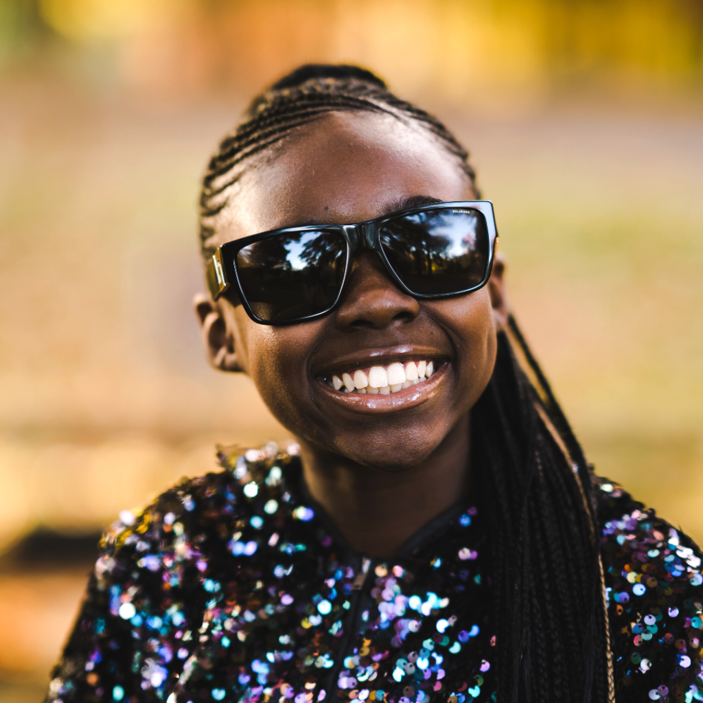 Image is of youn girl wearing glasses and smiling