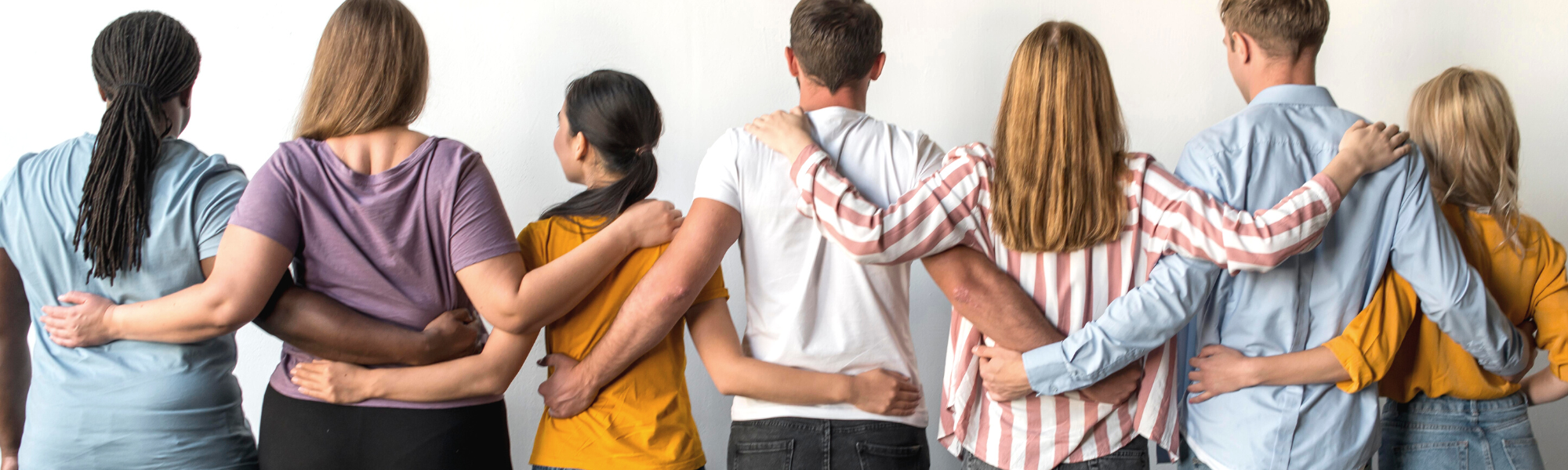 Image is of a group of people with their arms over each other's shoulders. Their backs are facing forward.