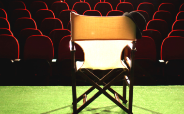 Image is of a director's chair in a theatre.