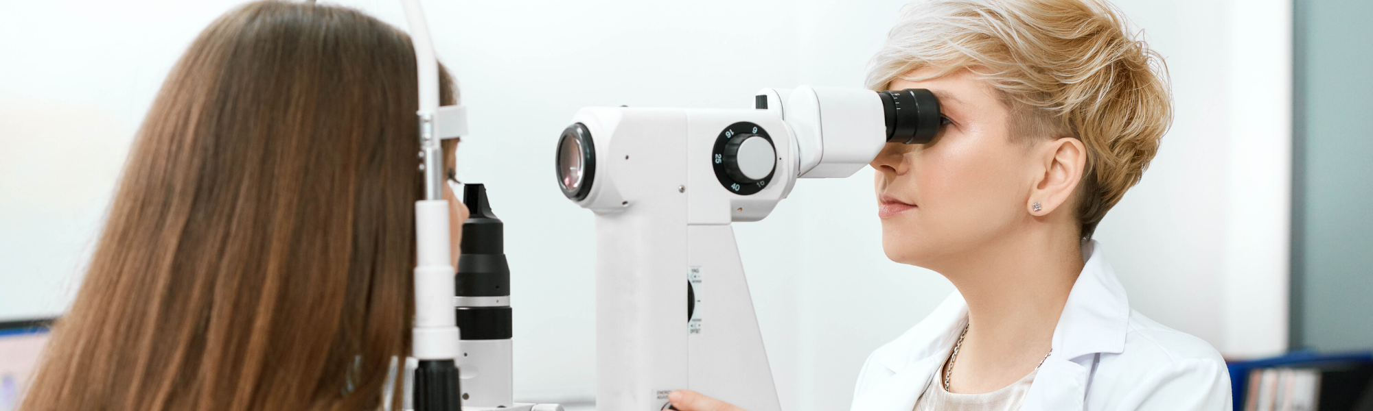 Image is of an eye doctor examining a patient.
