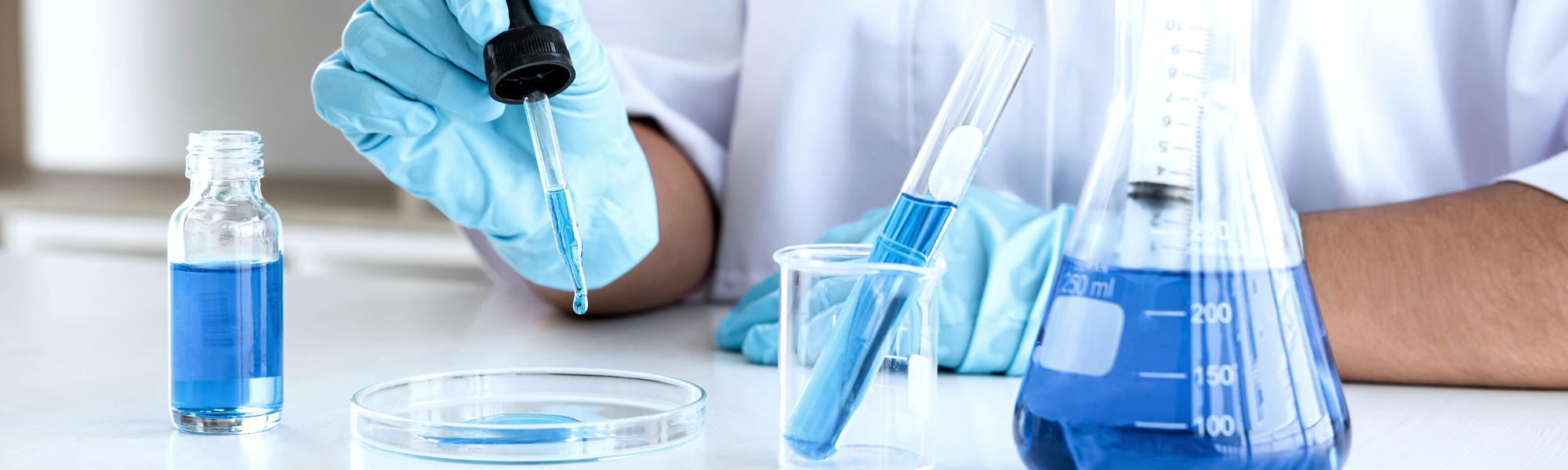 Image is of a researcher exploring liquids using medical viles.