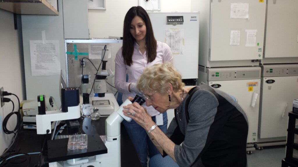 Image is of a Barbara Ritchie at the Dr. Nagy Lab with image is of Sabiha Hacibekiroglu smiling in the background. 