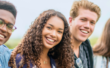 Image is of young diverse people smiling.
