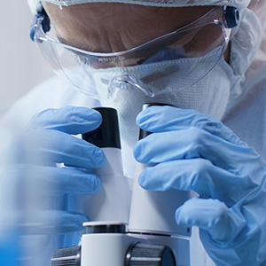 researcher looking in microscope