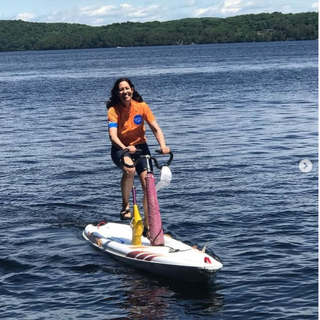 Image is of Ann Morrison on a water bike during a Cycle for Sight event. She is smiling.