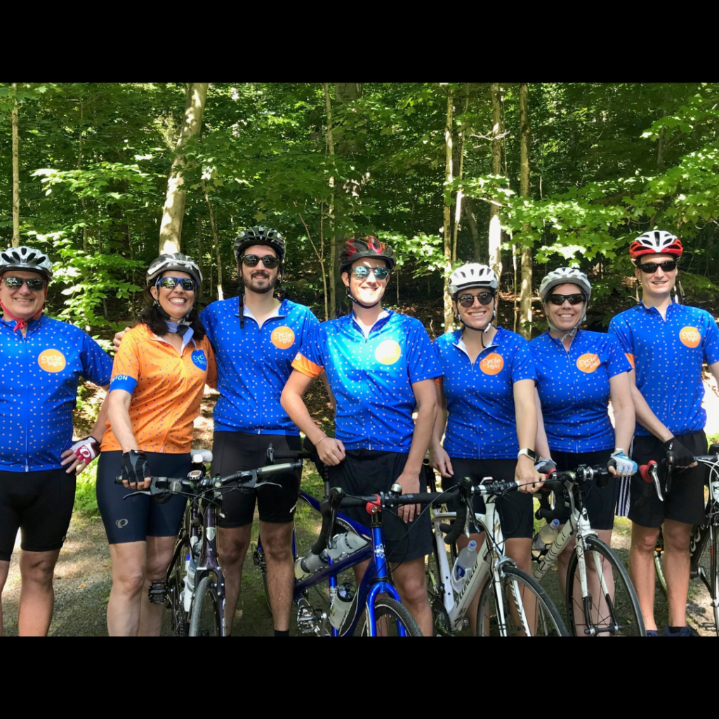 Image is of Ann Morrison with her family attending a Cycle For Sight event. They are all laughing and smiling.