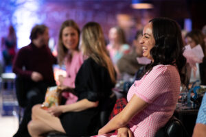 Image is of audience members and a close-up of a woman laughing during a stand-up routine during Comic Vision.