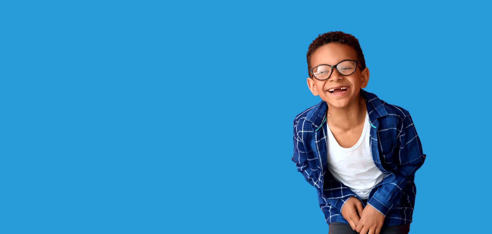 image is of a young boy wearing glasses and smiling.