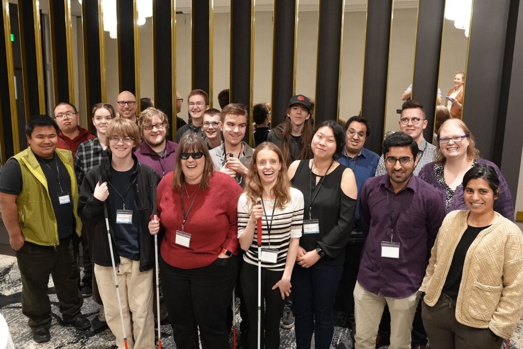 Image is of a group of Young Leaders smiling for the camera during an event.