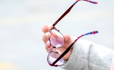 Image is of a woman holding glasses.