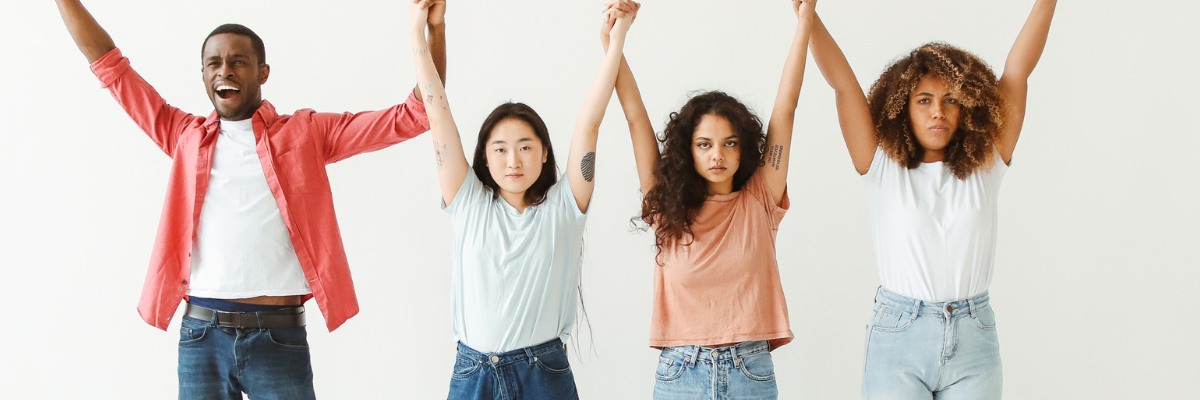 Four young people holding their arms up.