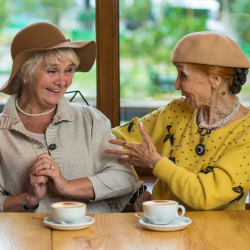 Group of elderly women sitting with coffee talking.