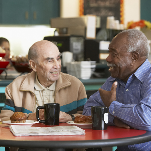 2 men sitting in a coffee shop talking