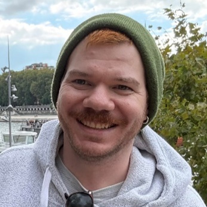Image of Benjamin Kent outside wearing a grey hoodie and a green toque