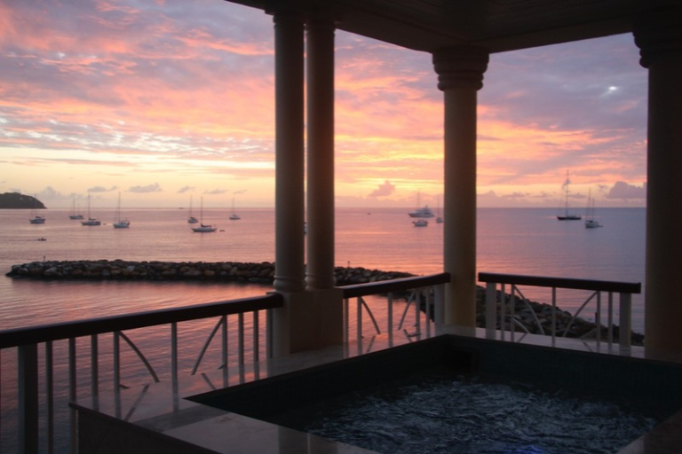 A lake or ocean at sunset taken from a porch